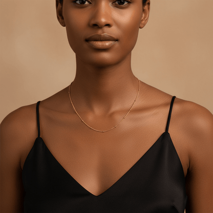 Woman wearing the Dotted Bead Chain Necklace alone as a minimalist choker with a black top.