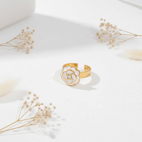 An artistic flat lay of The Fleur Ring styled with delicate dried flowers, emphasizing its timeless, Parisian-chic aesthetic.