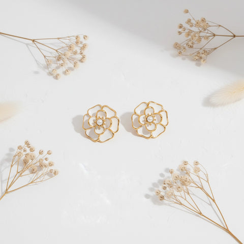 An artistic flat lay of The Fleur Studs styled with delicate dried flowers, emphasizing their romantic, Parisian-chic aesthetic.