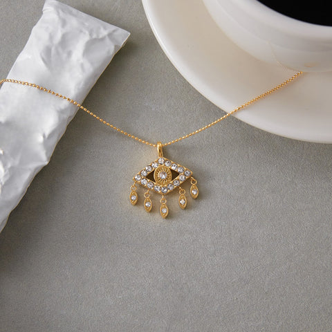 An artistic shot of The Fortuna Necklace styled next to a cup of coffee, illustrating it as the perfect good luck charm for your daily routine.