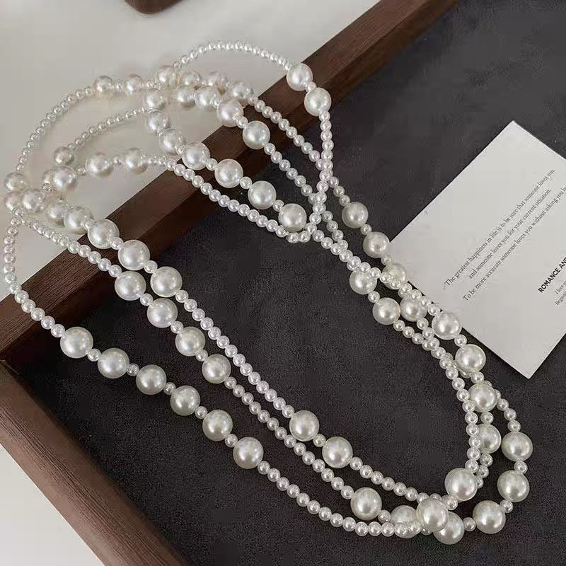 An artistic flat lay of The Gabrielle Necklace, emphasizing its impressive length and endless styling possibilities.