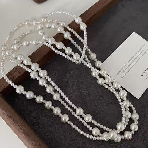 An artistic flat lay of The Gabrielle Necklace, emphasizing its impressive length and endless styling possibilities.