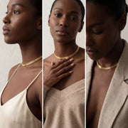 Model with dark skin wearing gold mesh necklace styled with blazer and top.