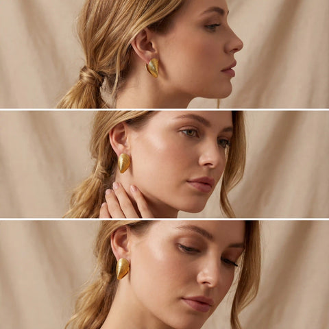 Blonde model styling gold mussel shell earrings for summer look.