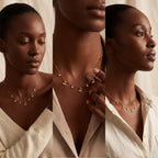 Model with dark skin wearing gold crystal station necklace elegant evening jewelry.