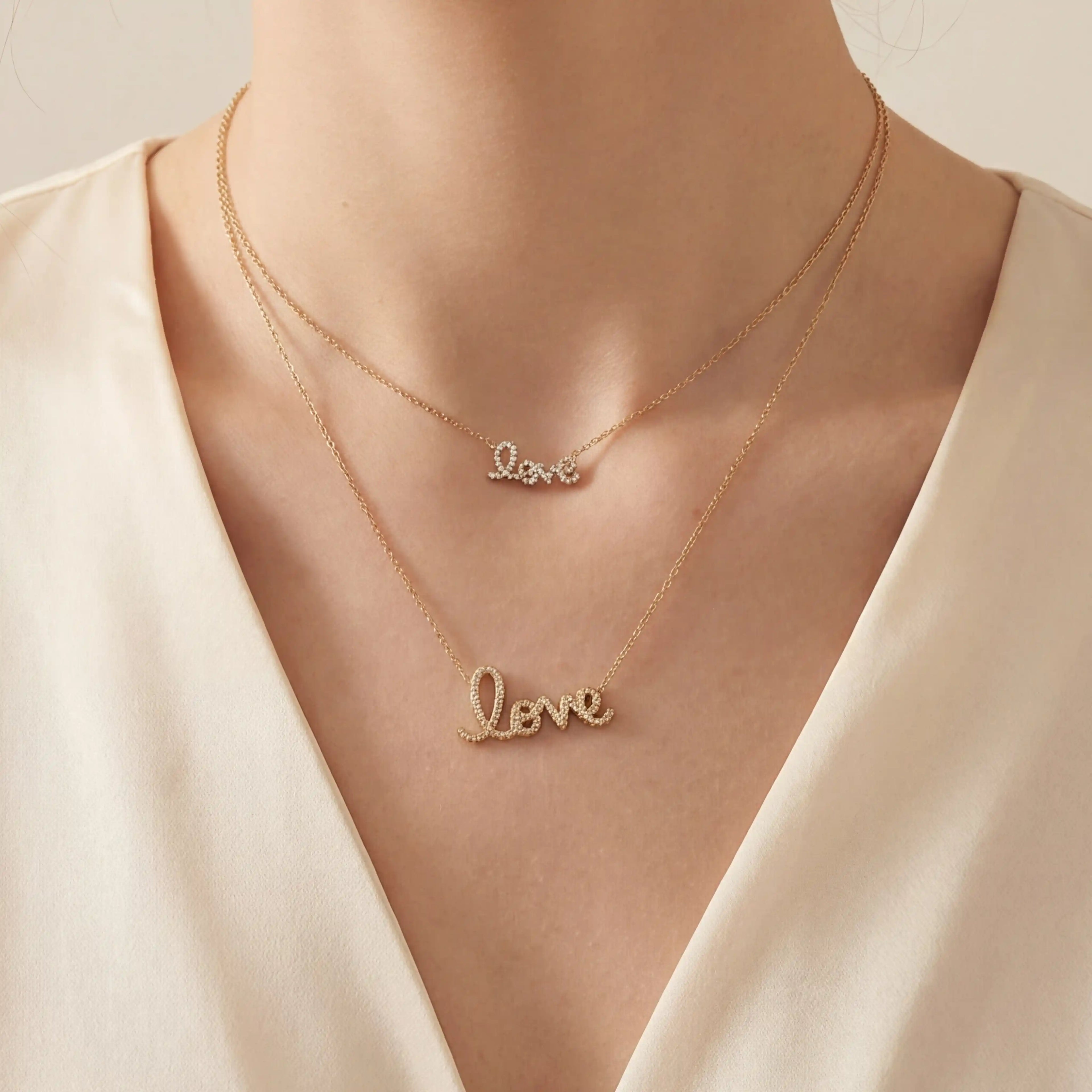 Close up of woman wearing layered gold and silver love script necklaces romantic jewelry.