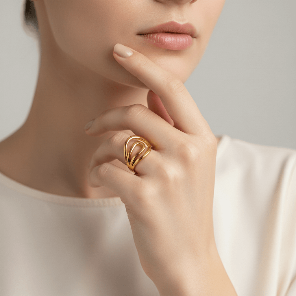 A model's hands are shown gently squeezing the open ends of the gold Liquid Gold Ring, demonstrating its adjustable cuff design for a perfect fit.