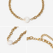 Aesthetic product photography details of textured gold links and baroque pearl necklace.