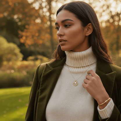 A model wearing a black, off-the-shoulder dress, with the dainty Luna Pearl necklace as the sole, elegant focal point on her décolletage. The shot showcases its timeless appeal for formal occasions.