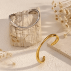 Minimal Wave Open Bangle — sculptural wave curve cuff bracelet in gold or dual-tone, elegant stacking piece.