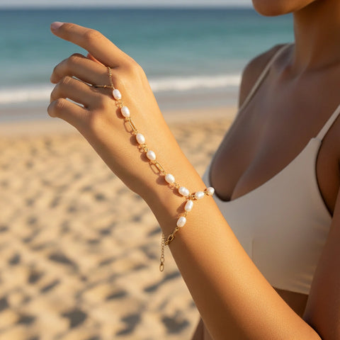 A model on a sunny beach wearing The Nereid Hand Chain, embodying the perfect waterproof accessory for a summer goddess or bohemian bride.