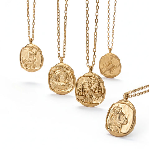 Collection of organic wax seal zodiac necklaces with matte gold finish and luxury box chains.