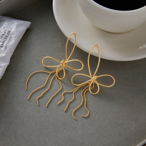 The Psyche Earrings styled next to a cup of coffee, illustrating them as the perfect, chic accessory for an everyday, sophisticated cafe look.