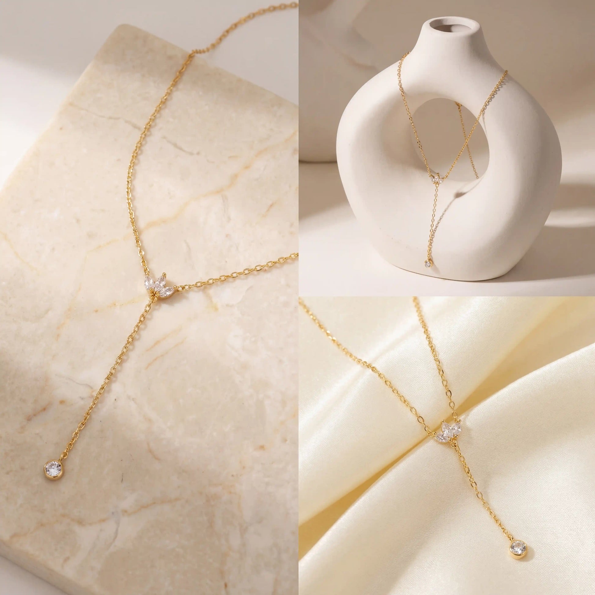 Aesthetic product photography of dainty gold lariat necklace on stone and silk background.