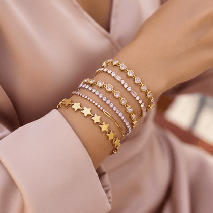 Detail shot showing the alternating pattern of pink baguette-cut crystals and clear round crystals on the gold tennis bracelet.
