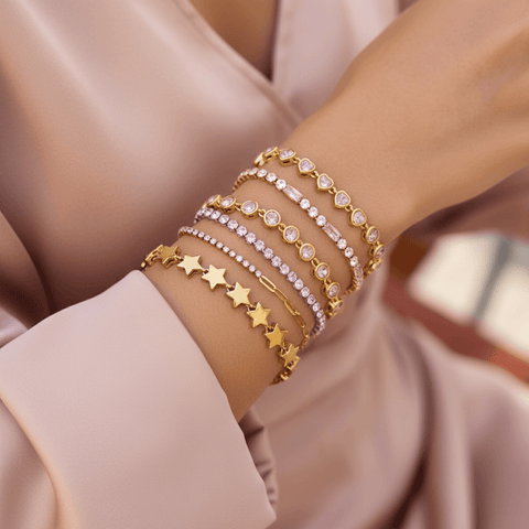Detail shot showing the alternating pattern of pink baguette-cut crystals and clear round crystals on the gold tennis bracelet.