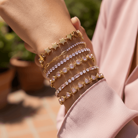 Model wearing the Sweetheart Pink Crystal Tennis Bracelet stacked with a gold watch.