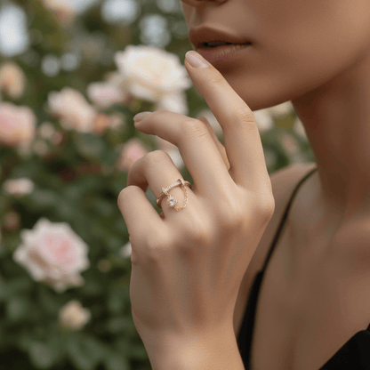 A model's hand holding a glass of iced coffee, with the delicate gold Comet Ring adding a touch of elegance to her casual look. The pavé charm catches the light beautifully.
