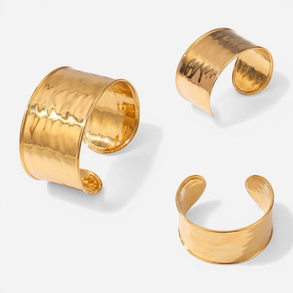 Aesthetic product photography of wide gold textured cuff bracelet angles on white background.