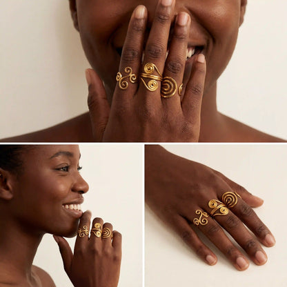 Model with dark skin wearing gold statement ring with spiral details smiling.