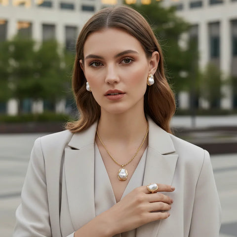 A model wearing the full Theia Goddess Set, including the necklace, earrings, and ring, with a sophisticated grey blazer for a powerful, professional statement.