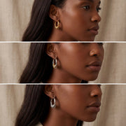 Model with dark skin wearing silver and gold chunky stacked earrings everyday look.