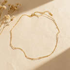 Extreme close-up of the dotted bead texture on the minimalist gold chain.