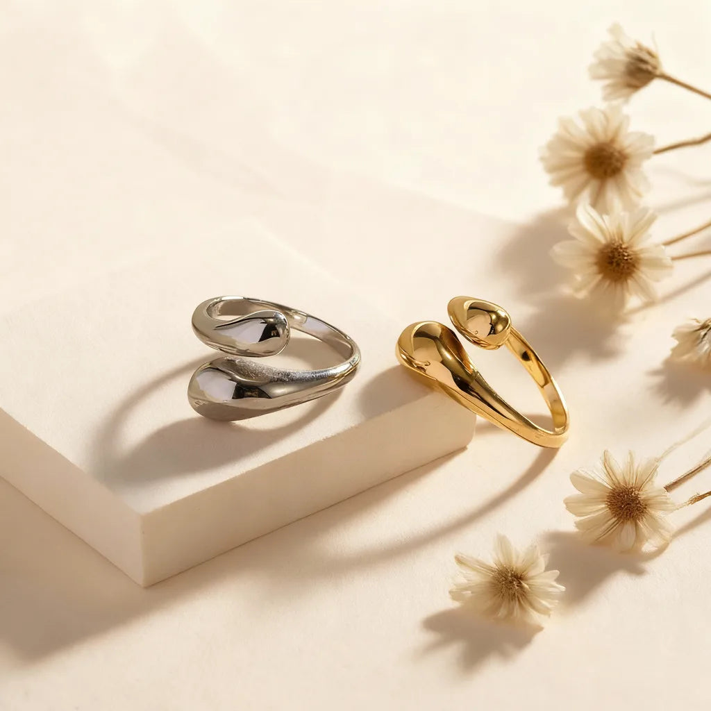 An artistic shot of the two-tone and all-silver Fluid Pebble Rings on a display block, emphasizing their fluid, interconnected design.