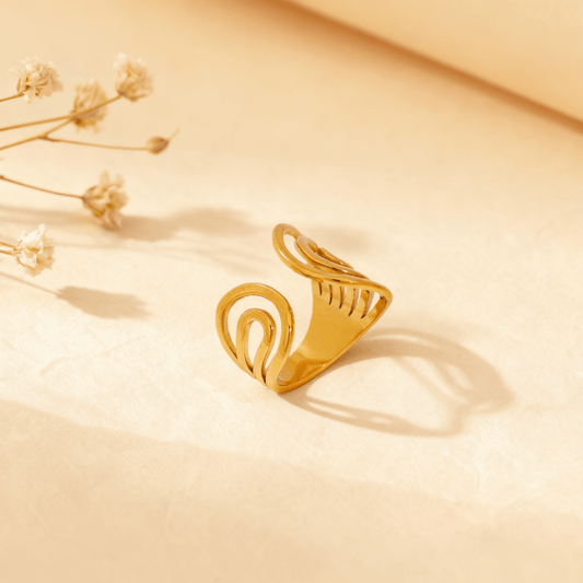 A macro close-up focusing on the unique 'plume' detail of the Liquid Gold Ring. The image clearly shows the parallel cutouts that create a ribbed, fan-like effect, highlighting the ring's intricate and architectural craftsmanship.