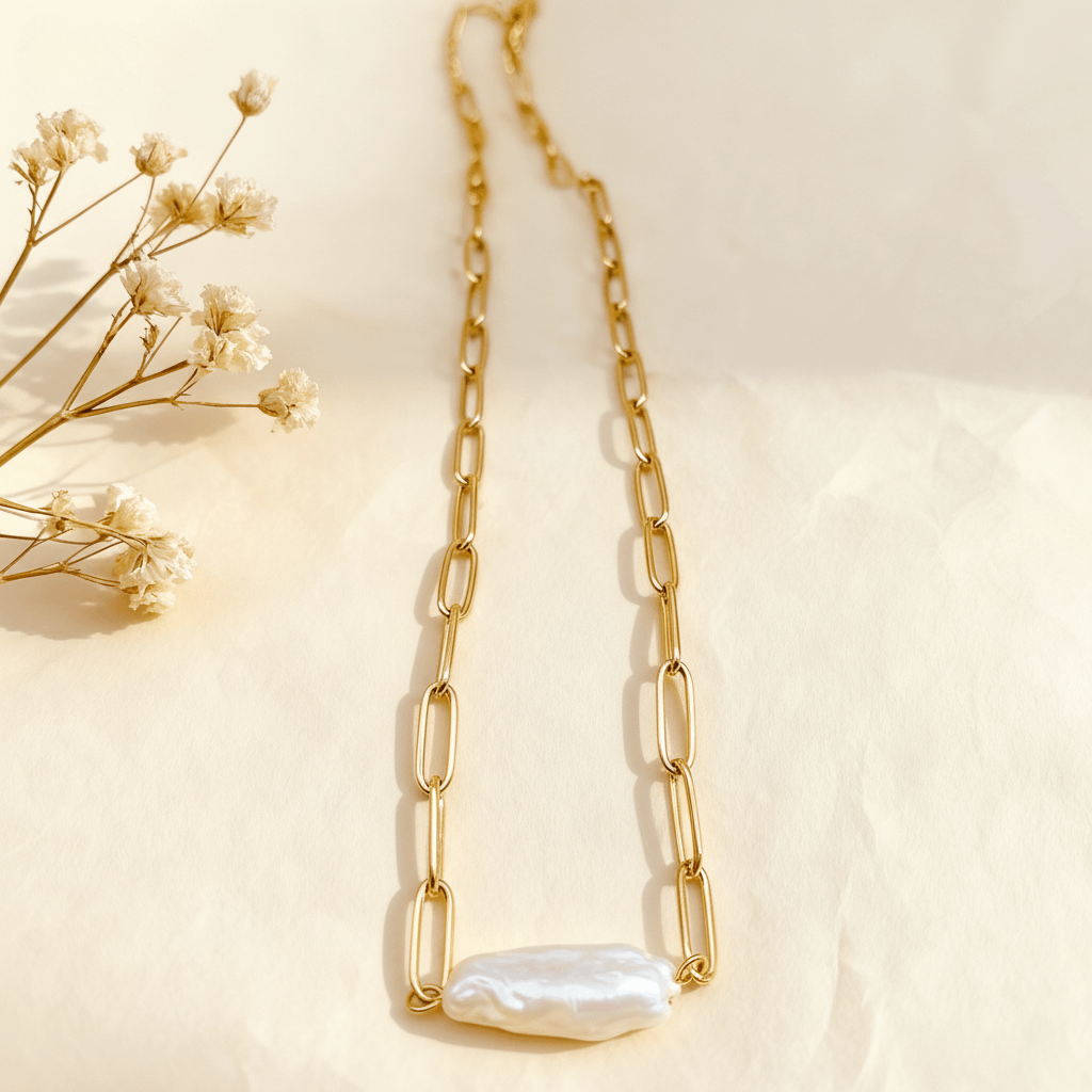A full-length view of The Aphrodite paperclip necklace, showing the entire tarnish-free gold chain and the unique baroque pearl pendant.