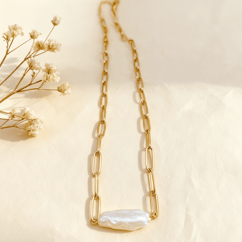 A full-length view of The Aphrodite paperclip necklace, showing the entire tarnish-free gold chain and the unique baroque pearl pendant.
