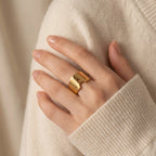 Close up of woman wearing chunky gold initial ring letter M personalized statement jewelry.