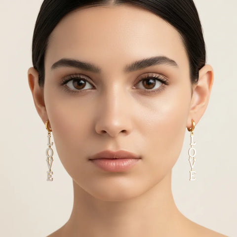 A beautiful front-facing portrait of a model wearing The Amor Earrings, showing how the long, linear drop design elegantly frames and elongates the face.