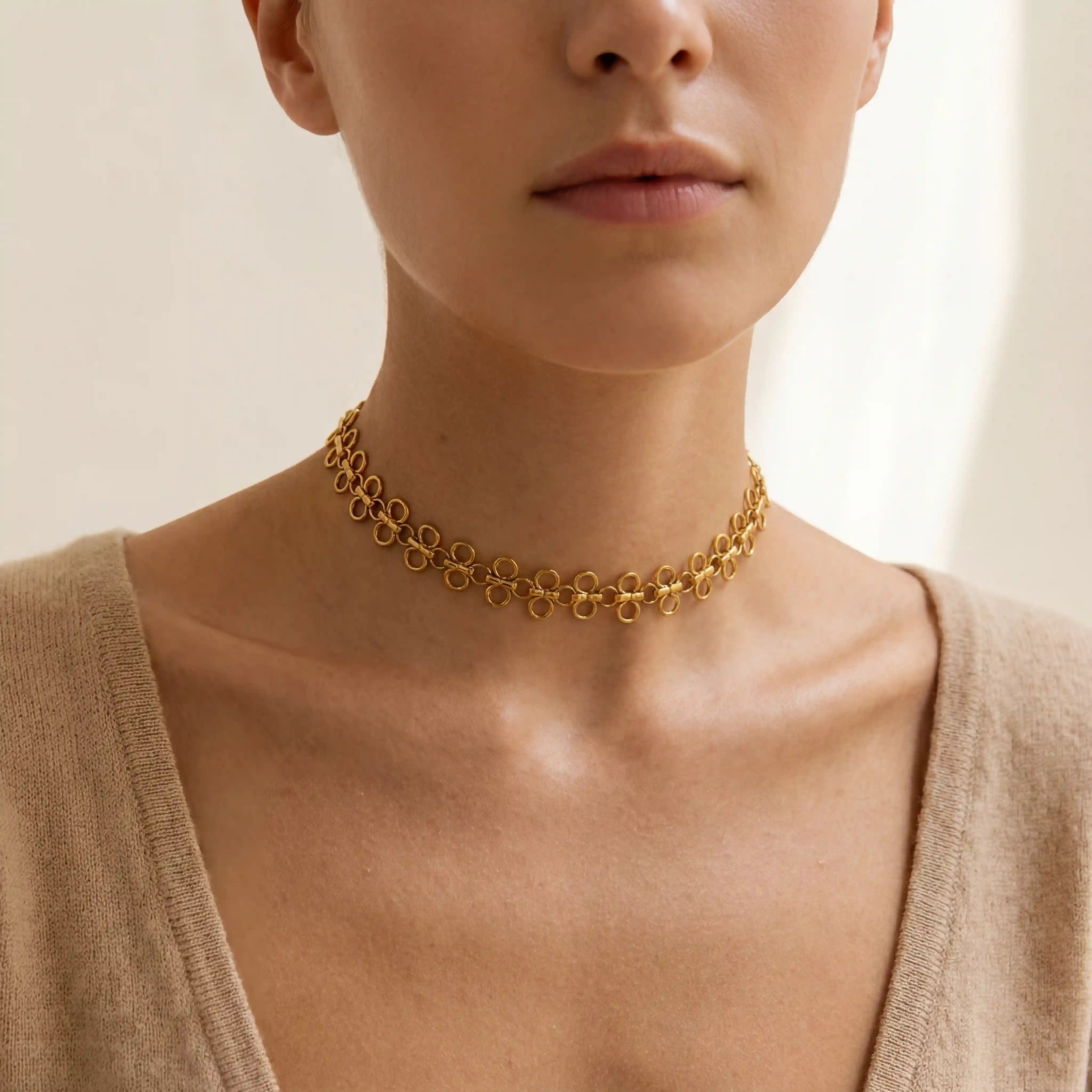 Close up of woman wearing Elodie gold choker necklace with unique disc link design. Main image