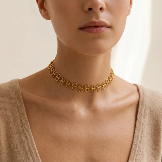 Close up of woman wearing Elodie gold choker necklace with unique disc link design.