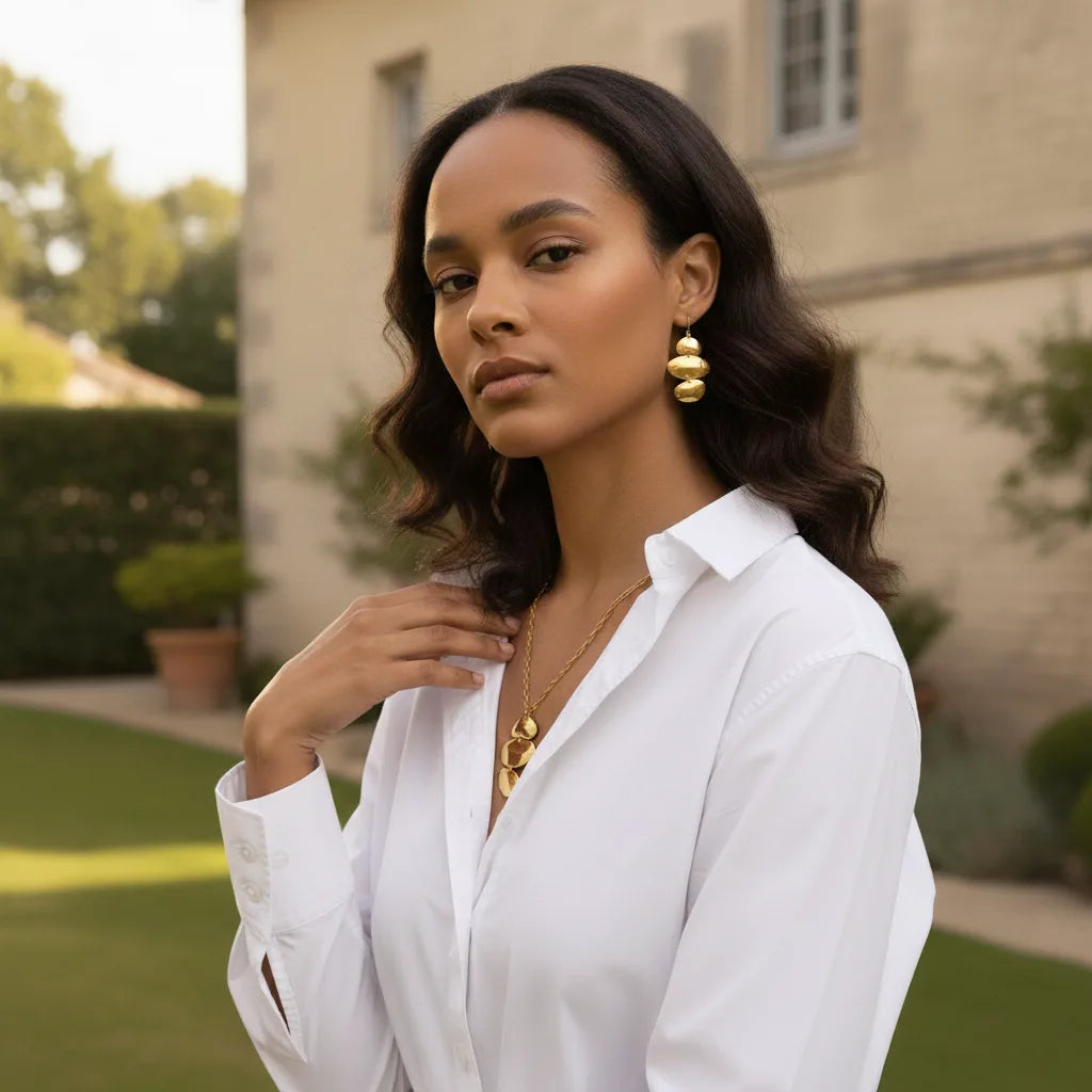 A stunning model showcasing the complete art collection, wearing The Thalia Necklace and the matching cascading Thalia Earrings for a powerful, coordinated look.