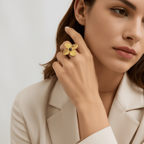 A model wearing a flowing linen dress holds a potted plant, with the Gaia Ring on her finger. The ring's earthy, natural design perfectly complements her bohemian, plant-lover aesthetic.