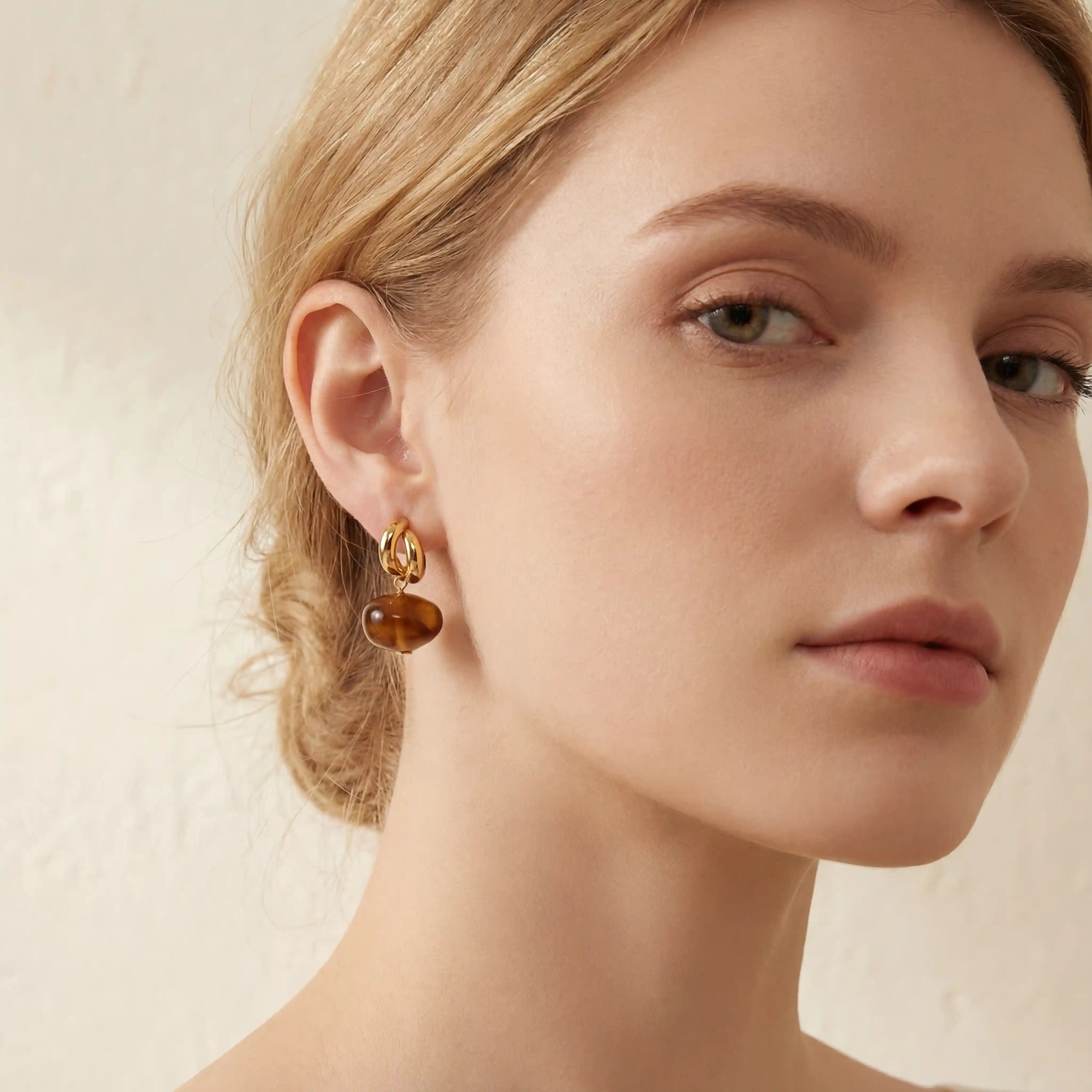 Portrait of woman wearing tortoiseshell resin drop earrings modern vintage look.