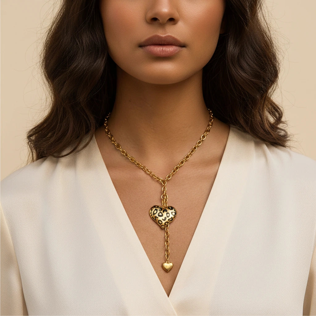 A beautiful close-up of a model wearing The Artemis Lariat, highlighting the vibrant leopard print heart against her skin with a classic white shirt.