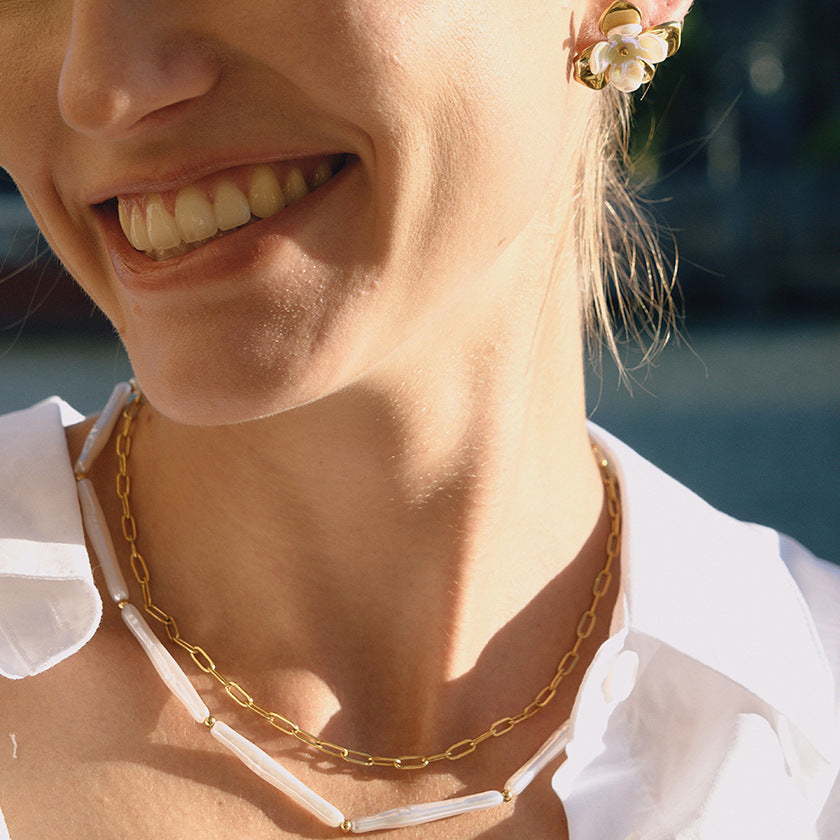 A smiling model wearing The Callisto Necklace, capturing the joyful, effortless chic of this versatile, modern classic piece.