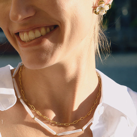 A smiling model wearing The Callisto Necklace, capturing the joyful, effortless chic of this versatile, modern classic piece.