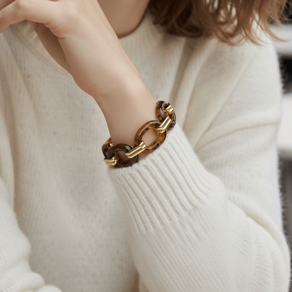 The Florence Link Bracelet worn by a model in a cozy white sweater, proving it's the perfect statement piece to instantly elevate a simple, everyday look.
