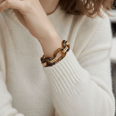 The Florence Link Bracelet worn by a model in a cozy white sweater, proving it's the perfect statement piece to instantly elevate a simple, everyday look.