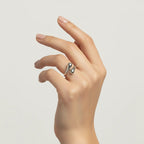 The all-silver Fluid Pebble Ring worn on a model's hand against a clean background, highlighting its sleek and contemporary aesthetic.