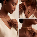 Model with dark skin wearing gold Jupiter necklace with green stone statement jewelry.