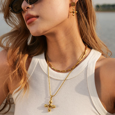 A stylish model wearing The Jupiter Necklace with the Tiger Eye stone, highlighting its bold, vintage presence on a gold rope chain against a white top.