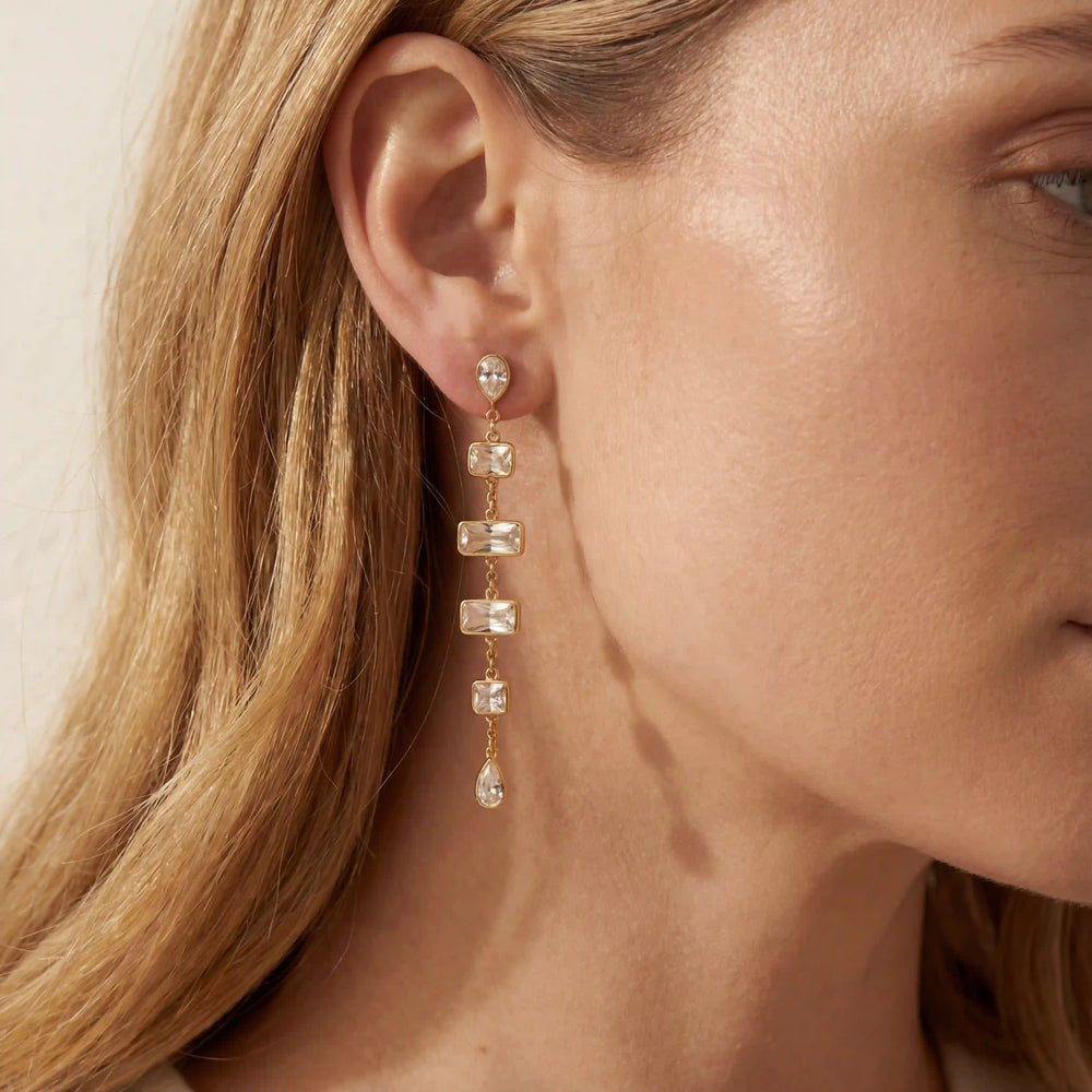Close up of woman wearing Lyra long linear drop earrings with geometric crystals elegant style.