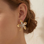 Close up of woman wearing O'Keeffe mixed metal flower stud earring artistic style.