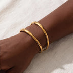 Minimalist jewelry styling gold geometric open cuff on woman wrist.