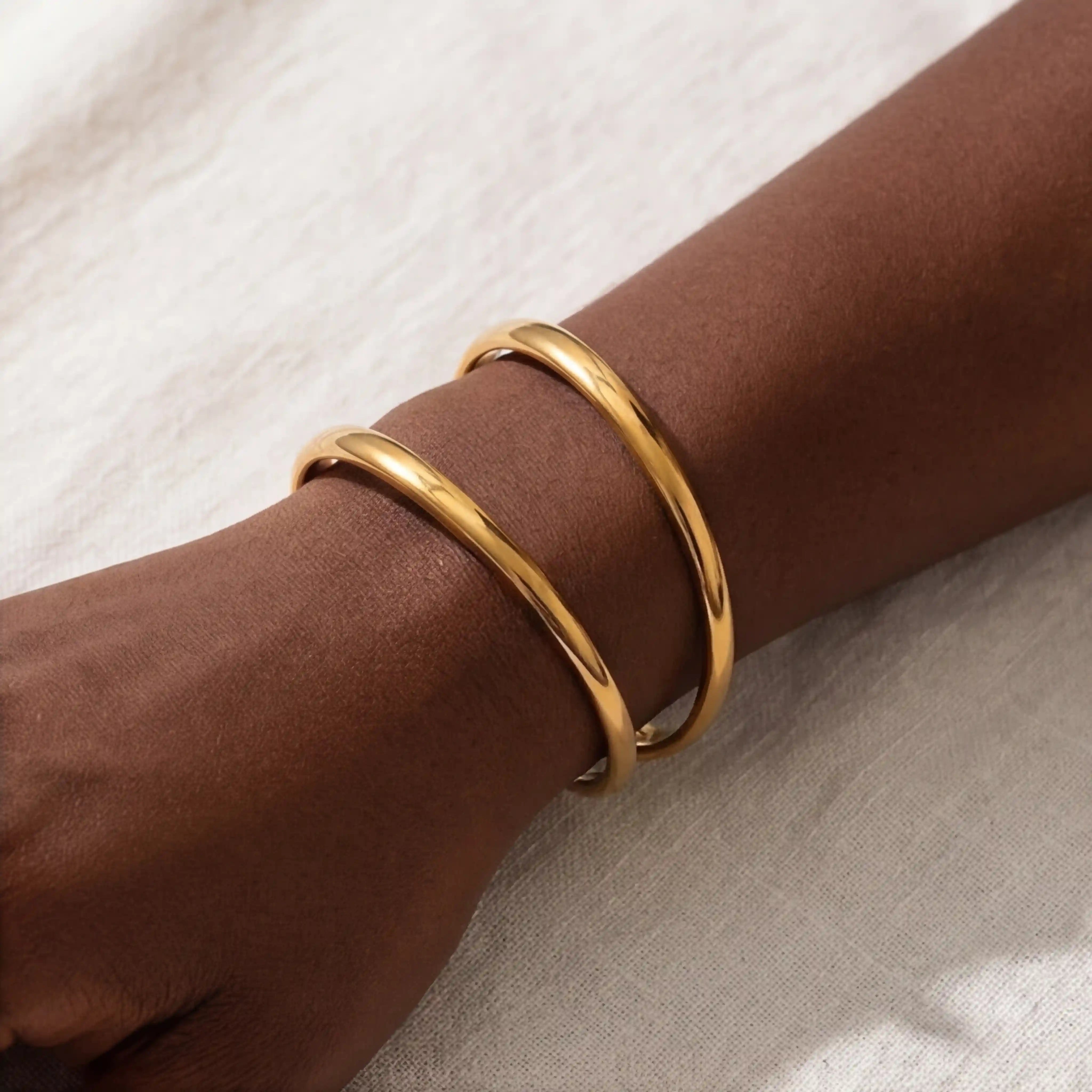 Minimalist jewelry styling gold geometric open cuff on woman wrist. Main image